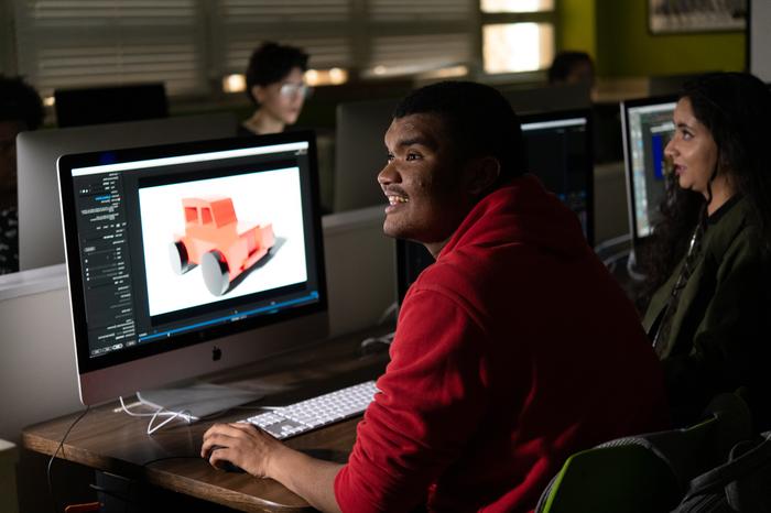 一个平面设计专业的学生在电脑前工作.