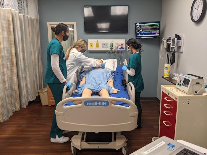 三个护生在模拟中心对一个模型病人进行练习.